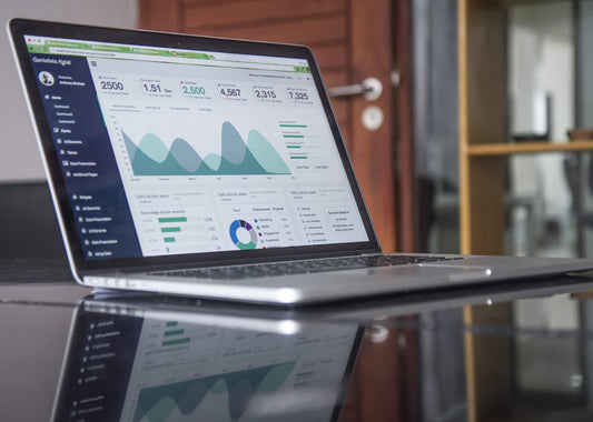 laptop on a desk showing analytics report and data with graphs