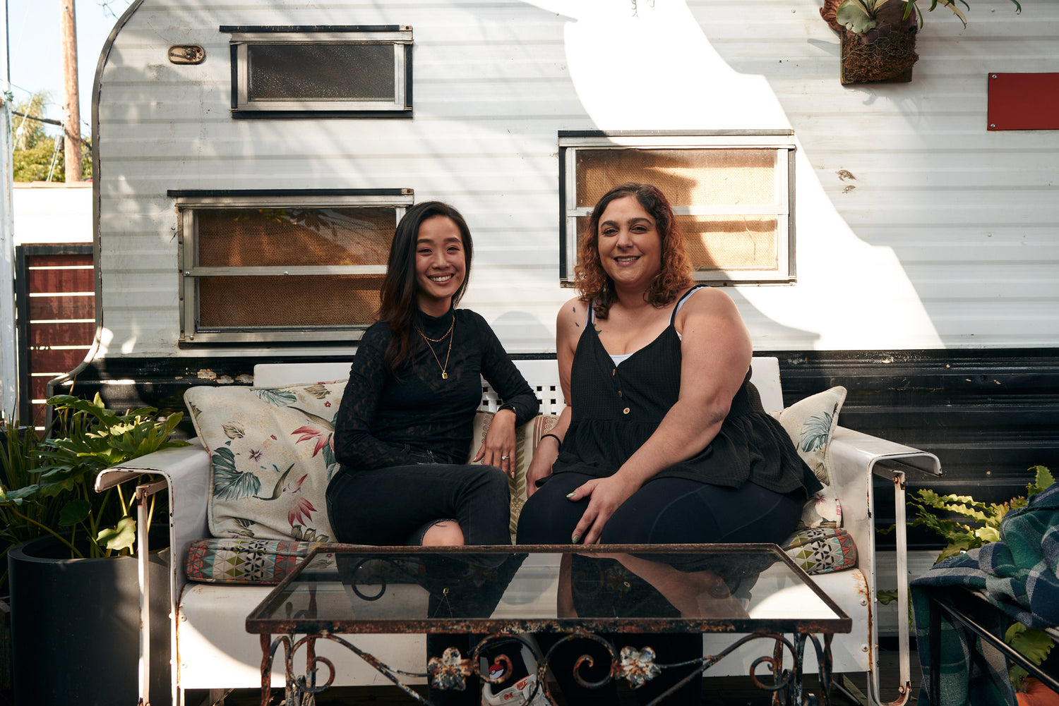Carol and Tasha, Qode Space founders, sitting in front of a trailer