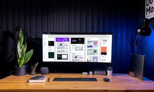 monitor sitting on a desk with a display of figma and multiple website designs