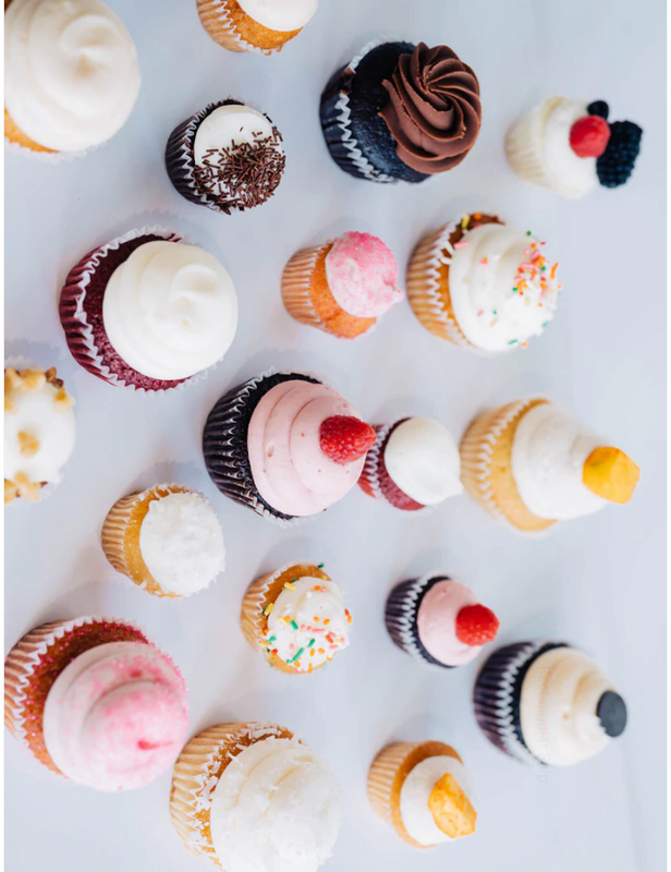 Several cupcakes of different flavors resting on a white table